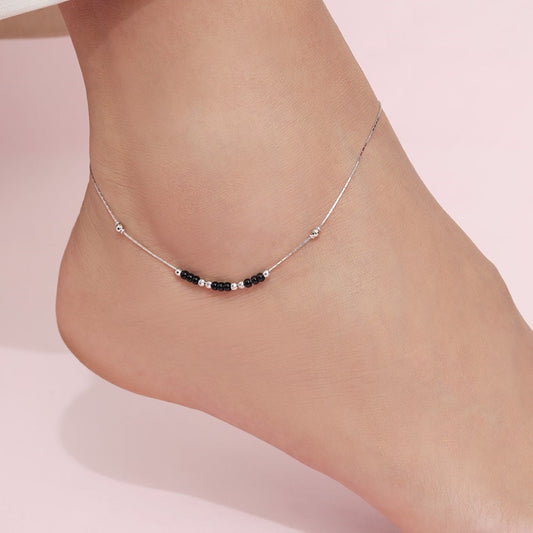 Woman wearing a 925 Sterling Silver anklet with black and silver beads. Fine women's jewellery – Zavya