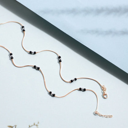 Rose gold-plated 925 Sterling Silver anklet for women featuring a delicate chain and black beads. – Zavya