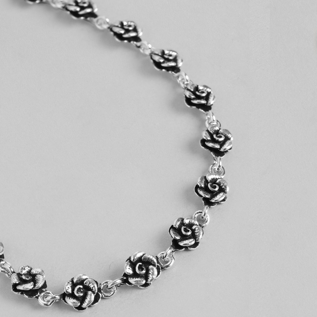 Women's 925 Sterling Silver floral anklet showing a close-up of detailed silver rose chain jewelry. – Zavya