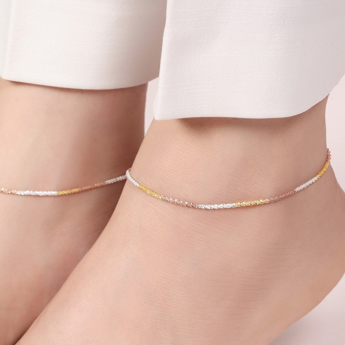 Woman wearing a triple tone weave 925 Sterling Silver anklet. Fine women's jewellery. – Zavya