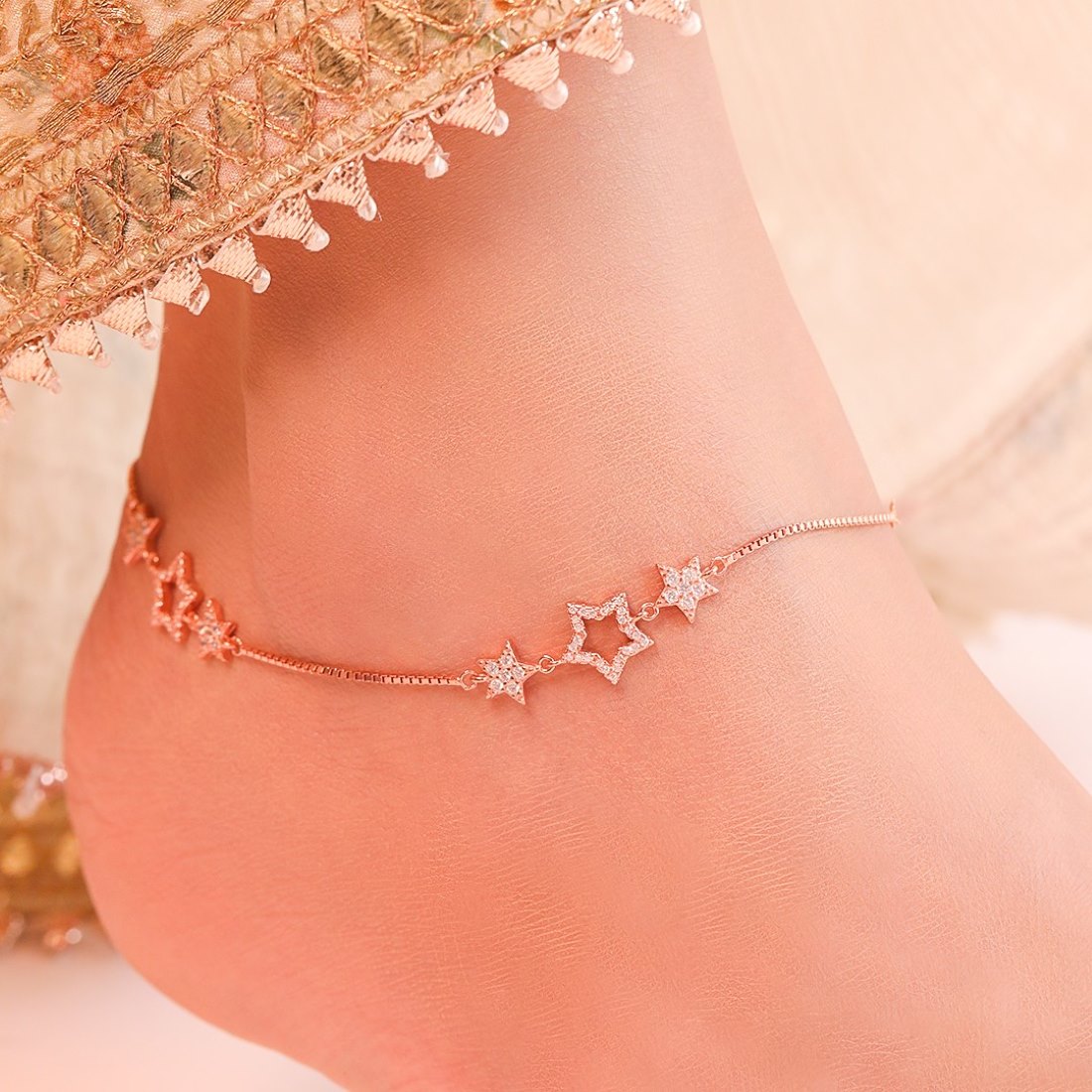 Woman wearing a rose gold plated 925 Sterling Silver anklet with cubic zirconia star charms. Women's jewelry – Zavya