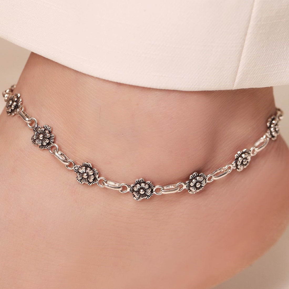 Woman wearing a floral 925 Sterling Silver anklet. Beautiful silver blossom jewellery for women – Zavya
