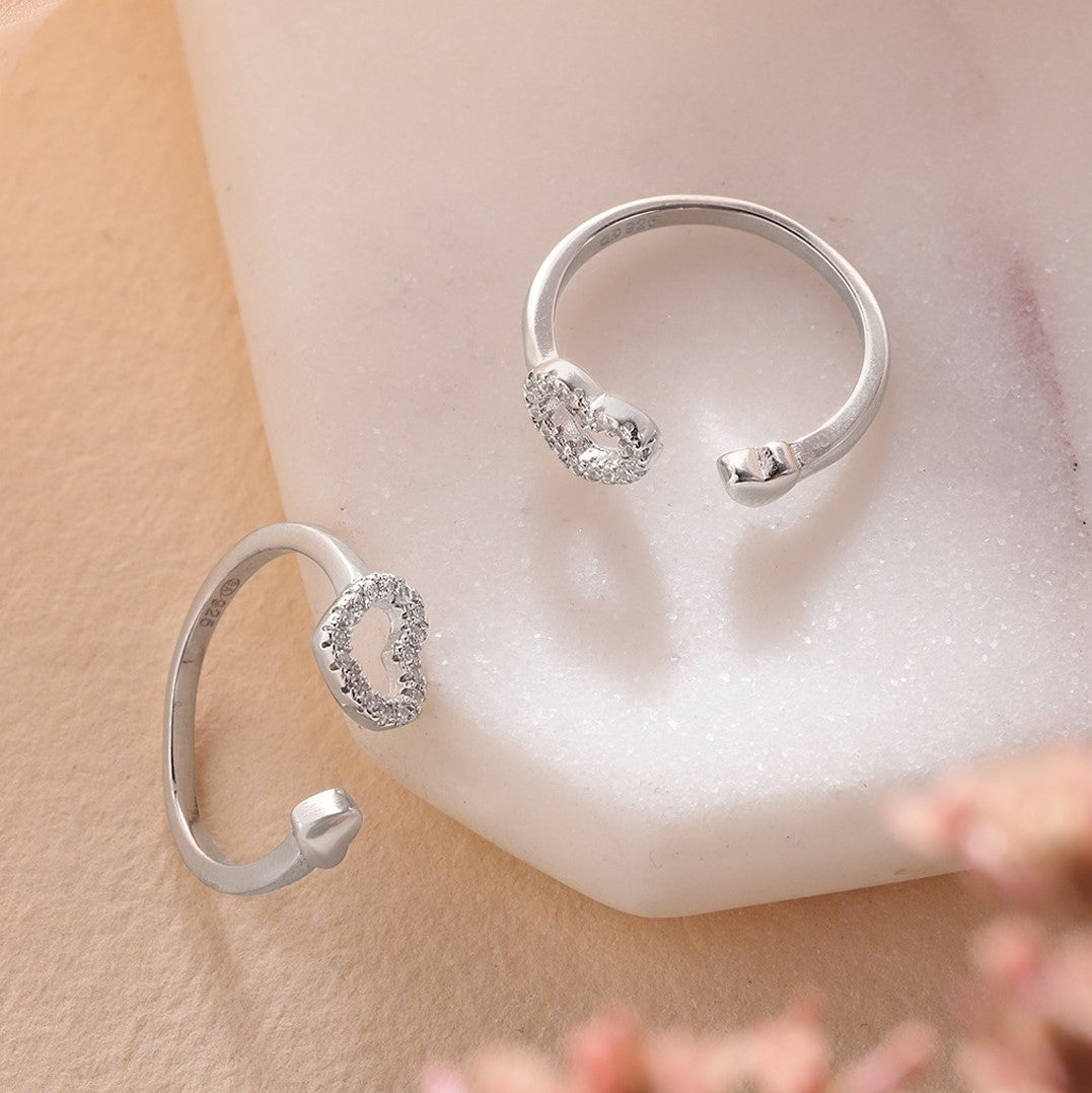 Two adjustable 925 Sterling Silver toe rings for women featuring sparkling heart designs on white marble. – Zavya