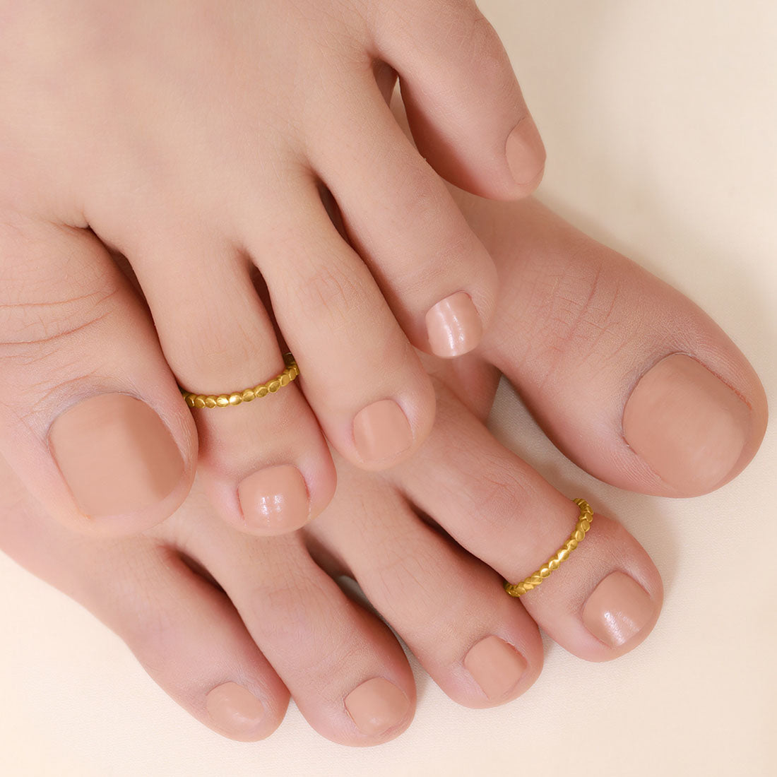 Woman's feet wearing textured gold plated 925 Sterling Silver toe rings. Classic jewellery for women. – Zavya