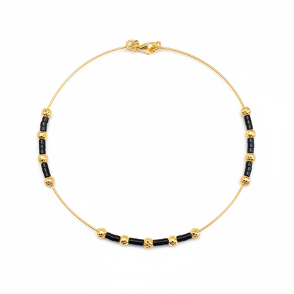 Gold and black beaded necklace on white background