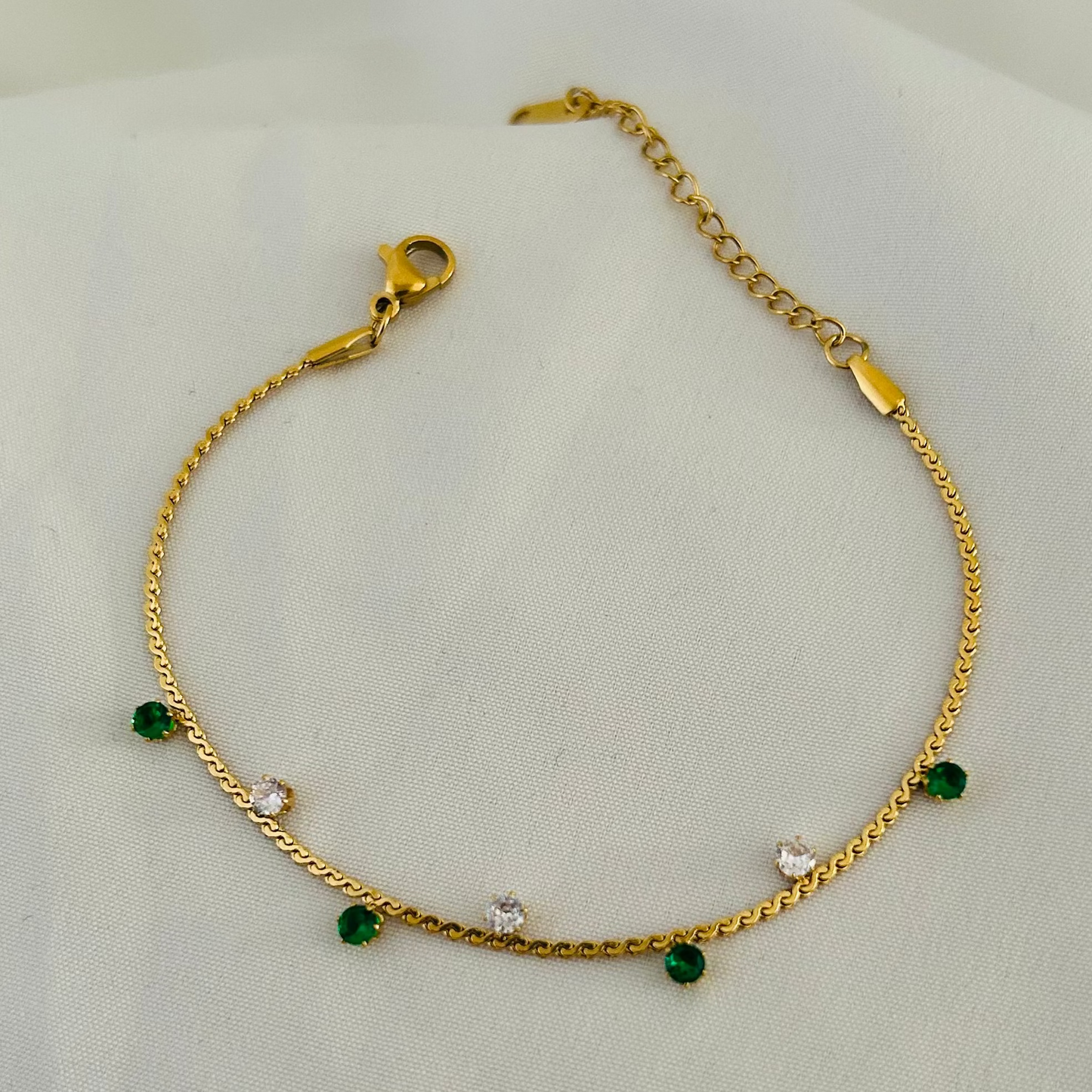 Gold bracelet with green beads and white stones