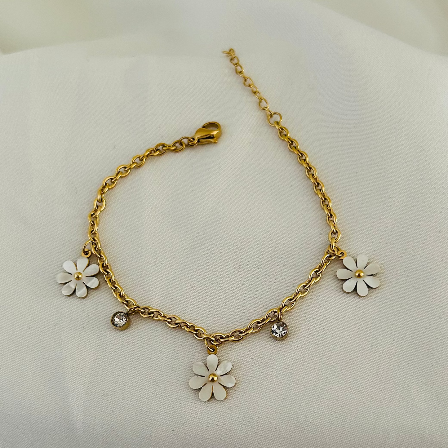Gold bracelet with white daisy flower charms