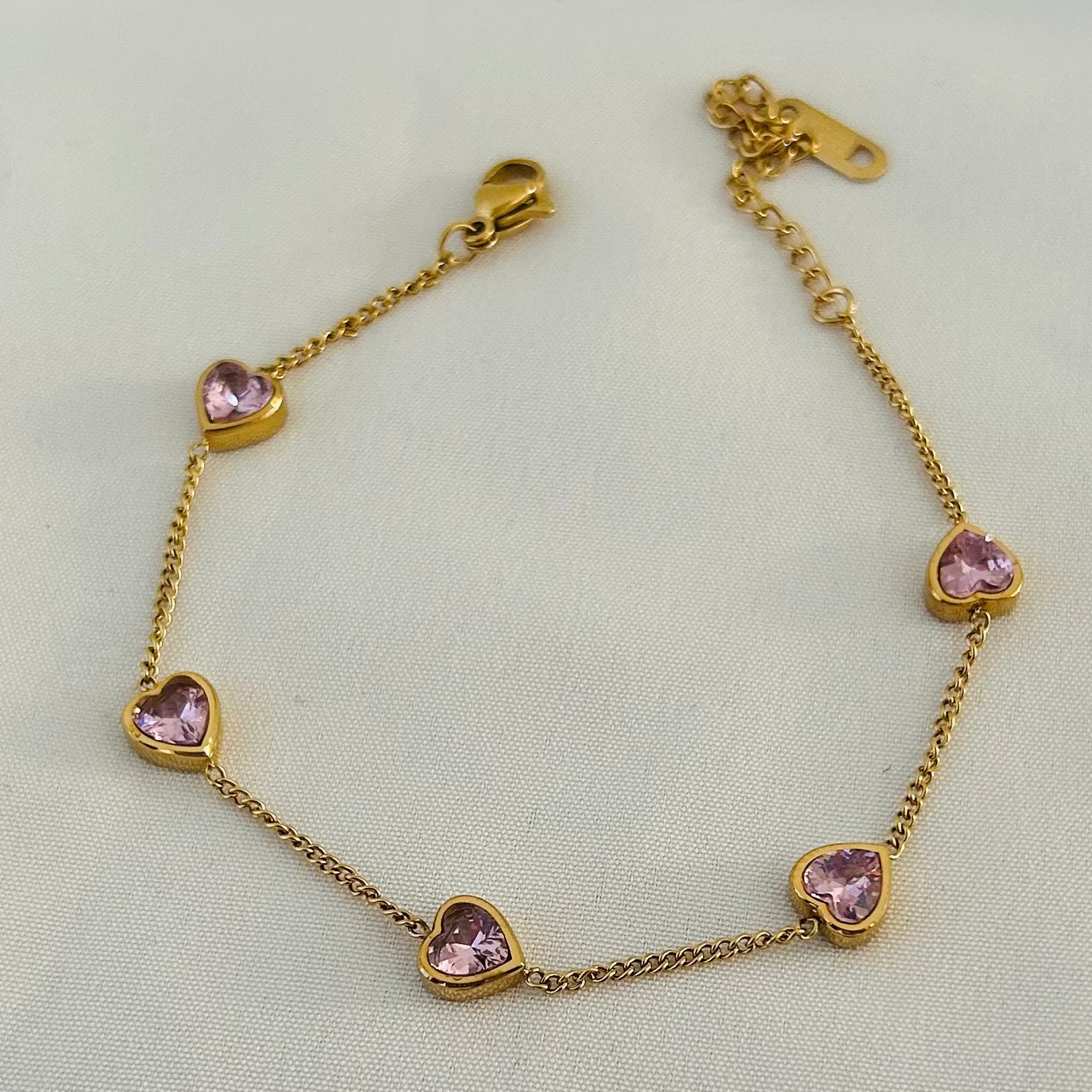 Gold bracelet with pink heart-shaped stones